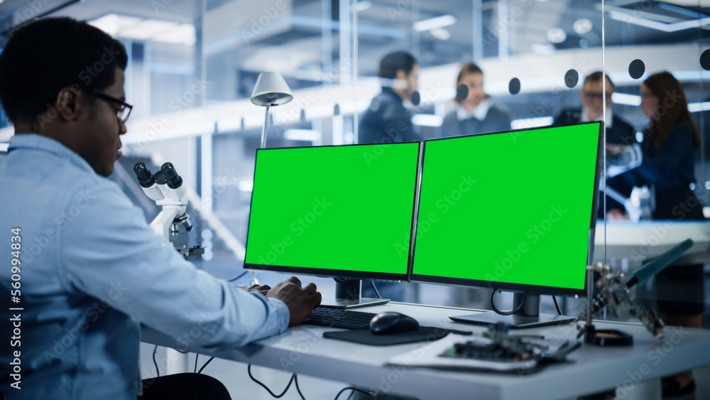 Software Developer Working on Computer with Green Screen Mock Up Display. Scientific Lab, Engineerin