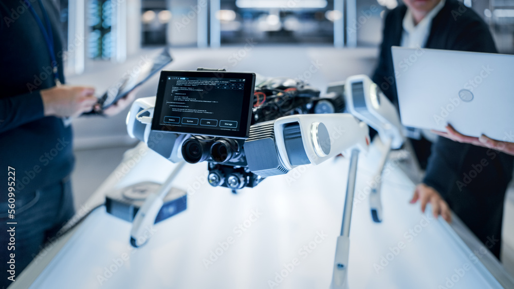 Close Up Robot Dog Prototype with Smiling Emoji Face on Display Standing in a High Tech Modern Indus