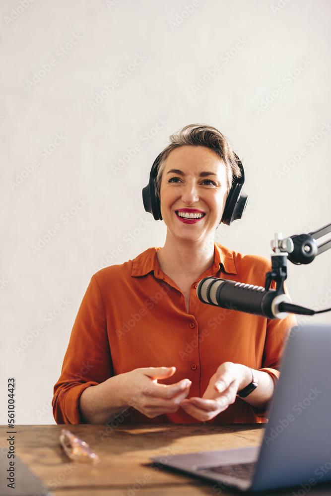 Happy female podcaster smiling in a home studio