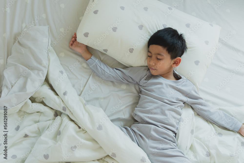 Top View of Asian boy having good dreams while Sleeping Cozily