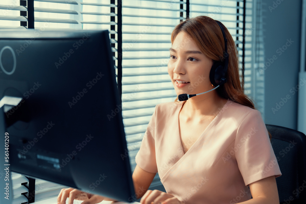 Competent female operator working on computer and while talking with clients. Concept relevant to bo