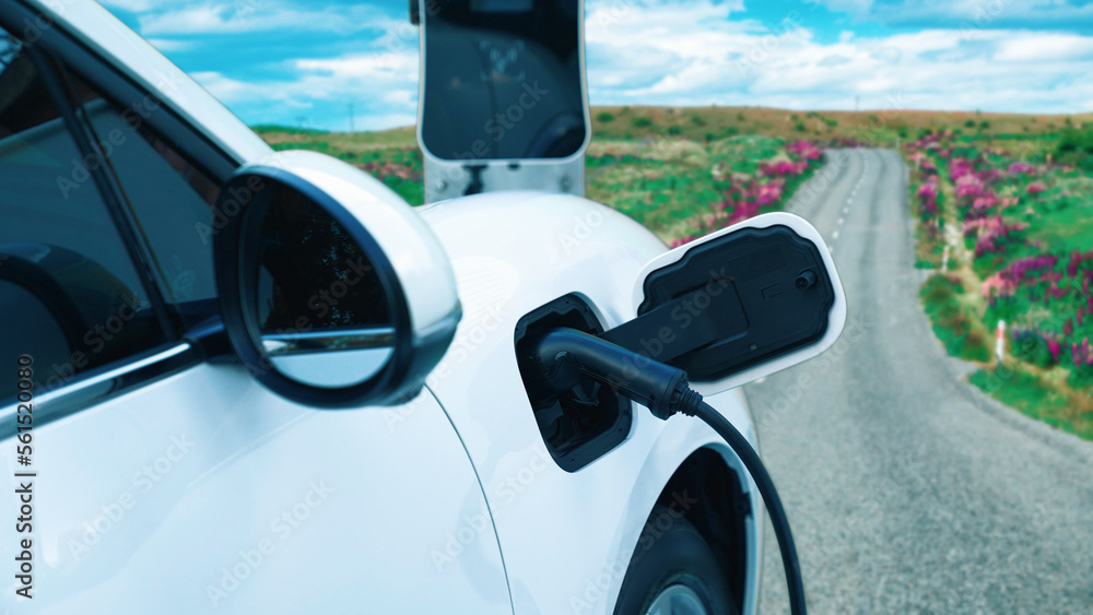 Progressive concept for environmental awareness by electric car at the charging station on the hill 