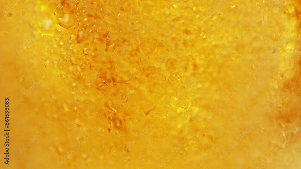 Water drops with beer bubbles in glass, close-up.