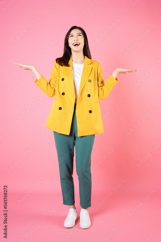 Full length image of young Asian business woman standing on background