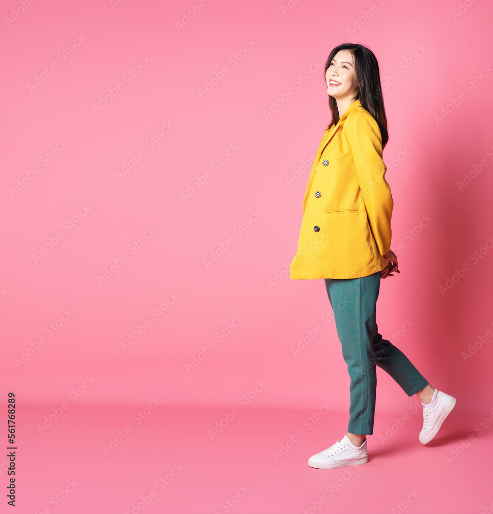 Full length image of young Asian business woman standing on background