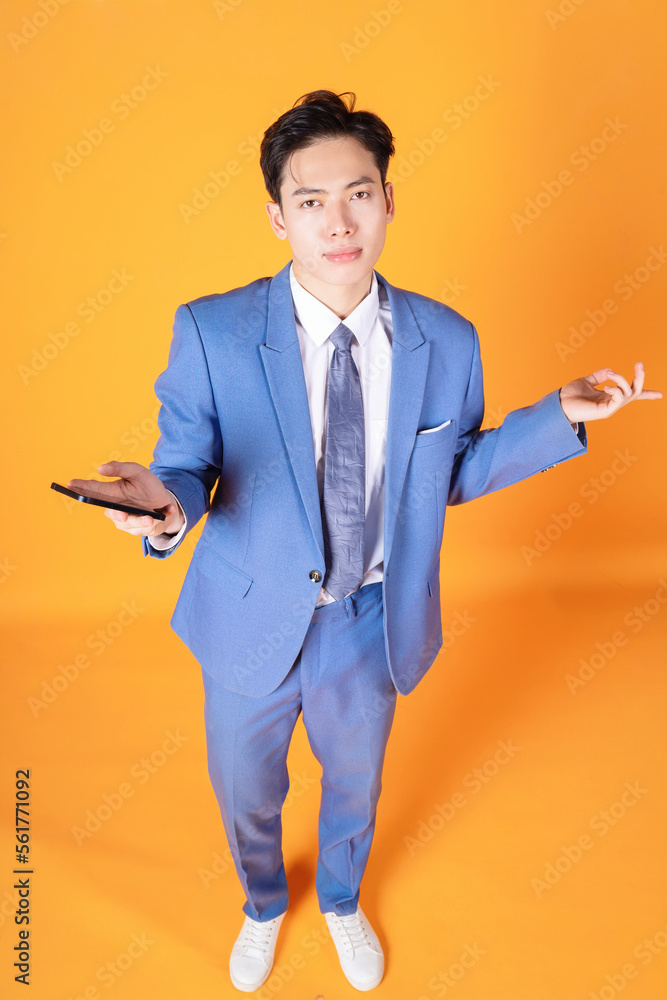 Portrait of young Asian businessman using smartphone on background