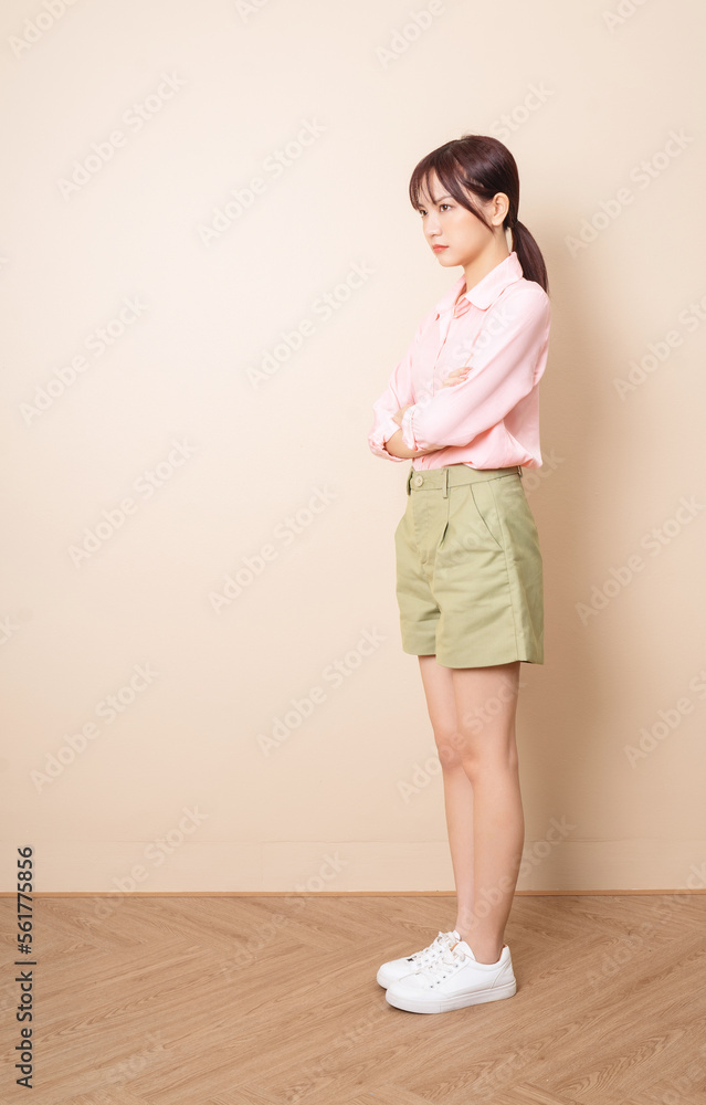 Full length photo of young Asian woman standing on background