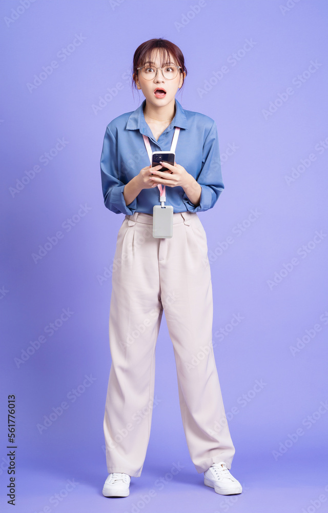 Photo of young Asian businesswoman holding smartphone on background