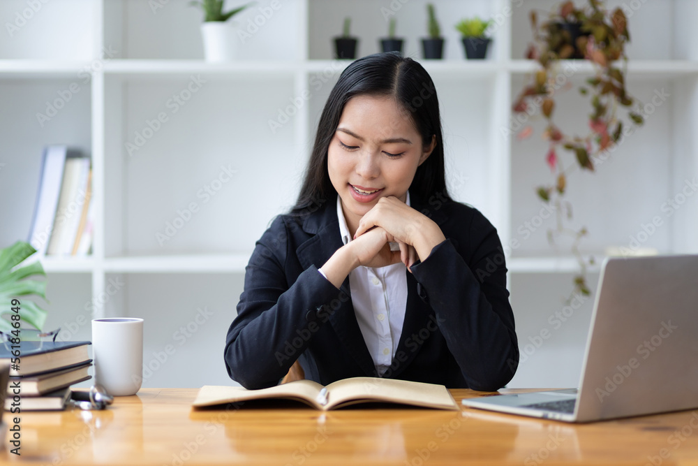 美丽的亚洲女商人在办公室里用笔记本电脑工作的肖像。