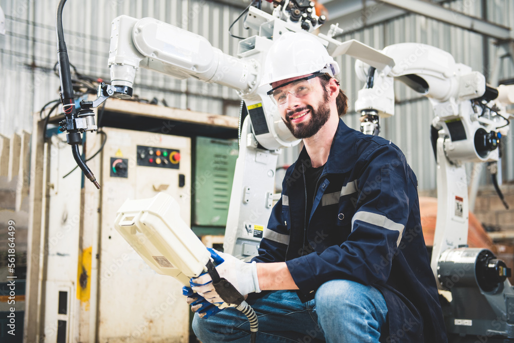 Engineers team mechanic using computer controller Robotic arm for welding steel in steel factory wor