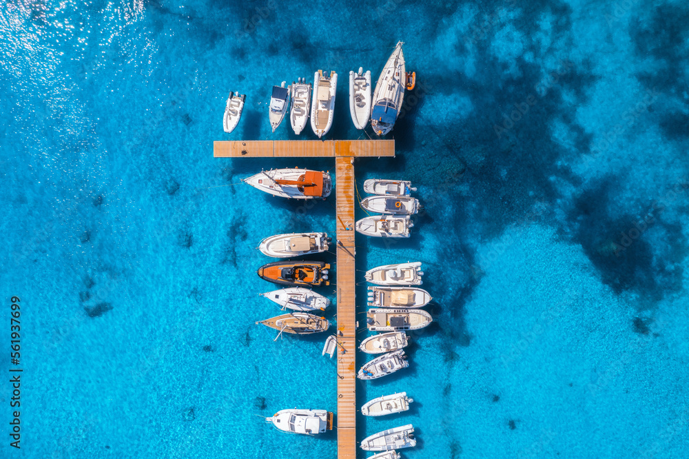 Aerial view of boats and luxure yachts in dock at sunset in summer in Sardinia, Italy. Colorful land