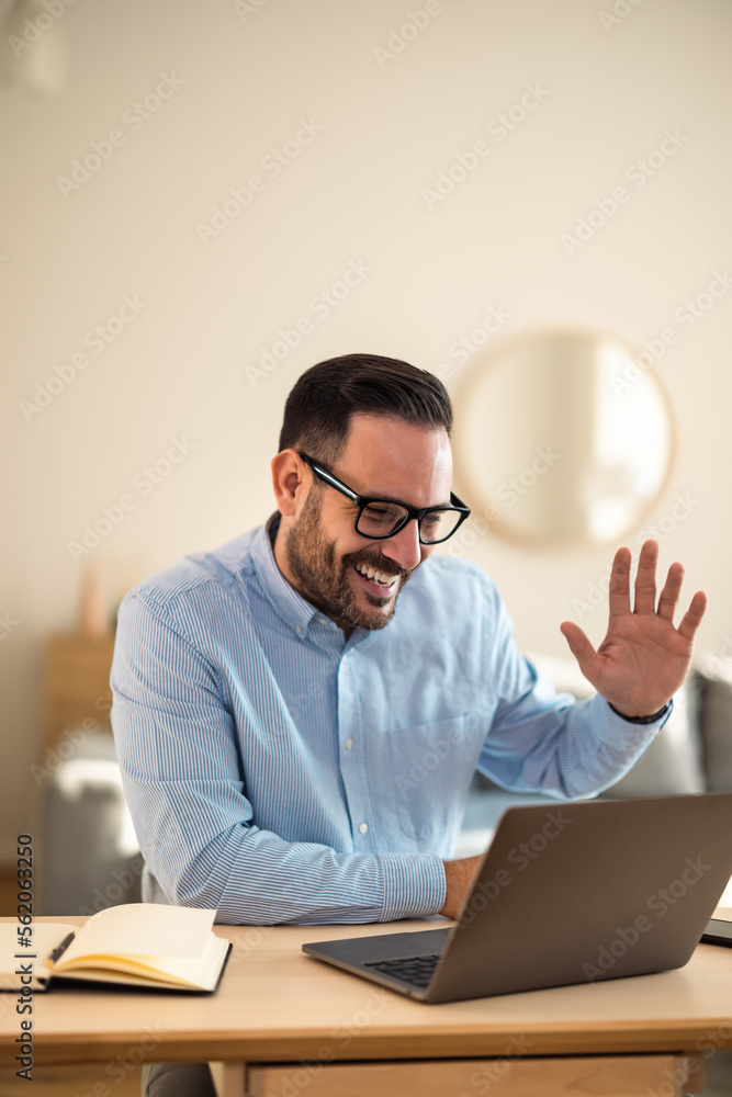 Businessman having an online meeting with clients over the laptop, at the home office.