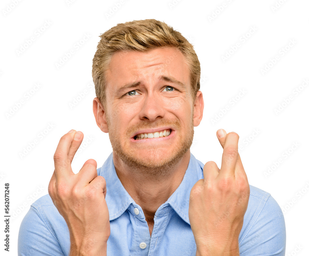 A handsome young man standing alone in the studio and feeling nervous while crossing his fingers iso