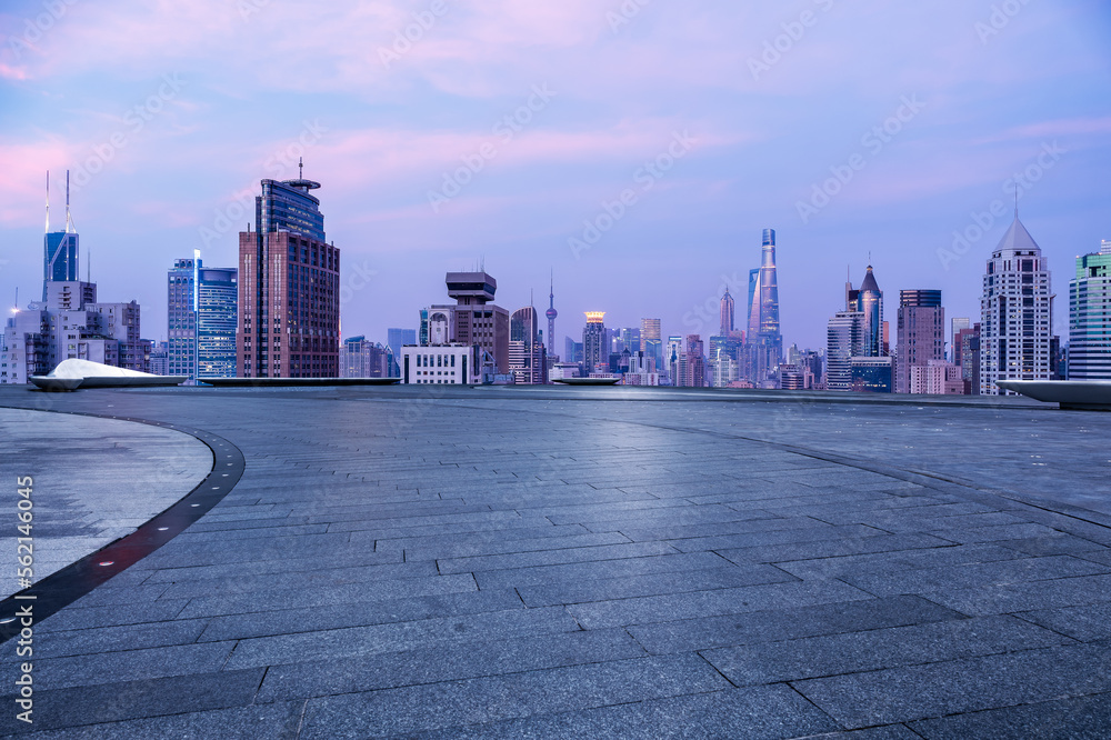 Empty square floor and city skyline with modern buildings at sunset in Shanghai, China.