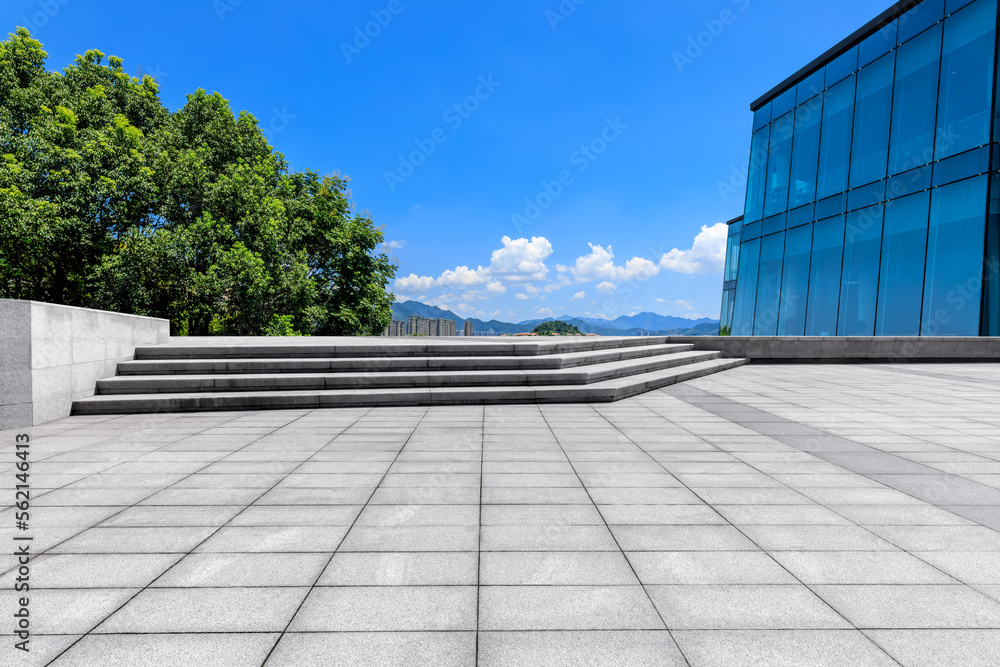 公园里空荡荡的方形地板和绿树，玻璃墙风景