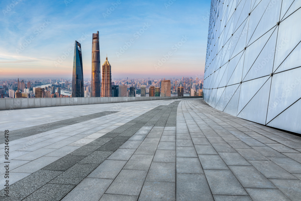 Empty square floor and city skyline with modern buildings at sunrise in Shanghai, China.