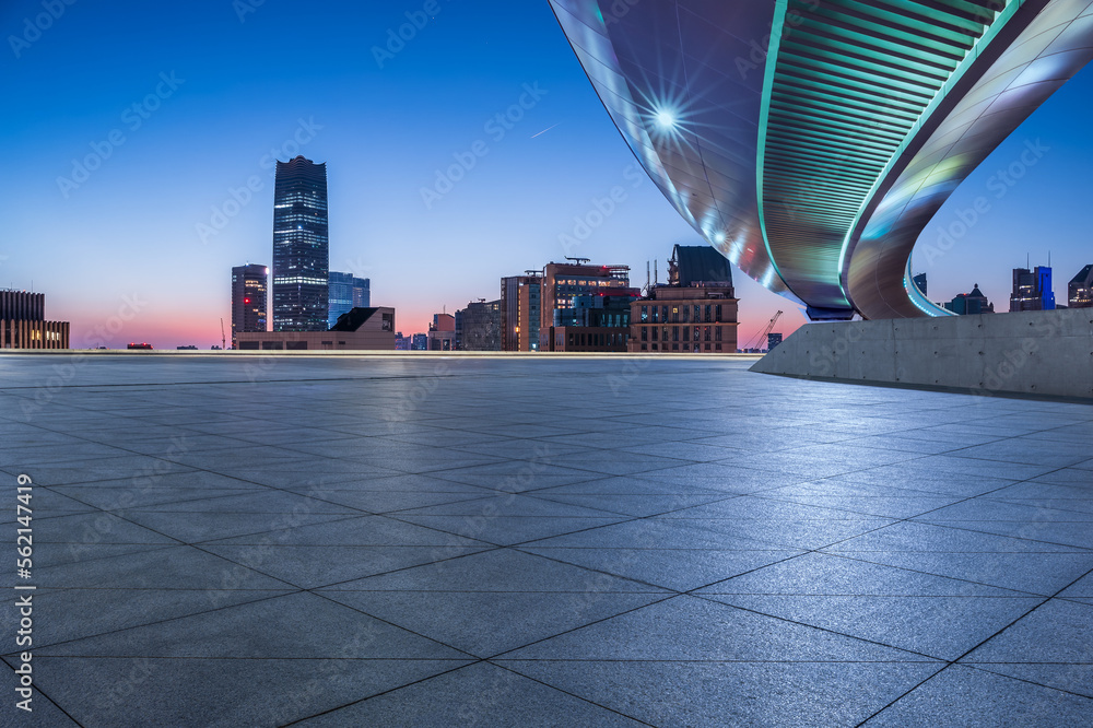 Empty square floor and bridge with city skyline at sunrise in Shanghai, China.