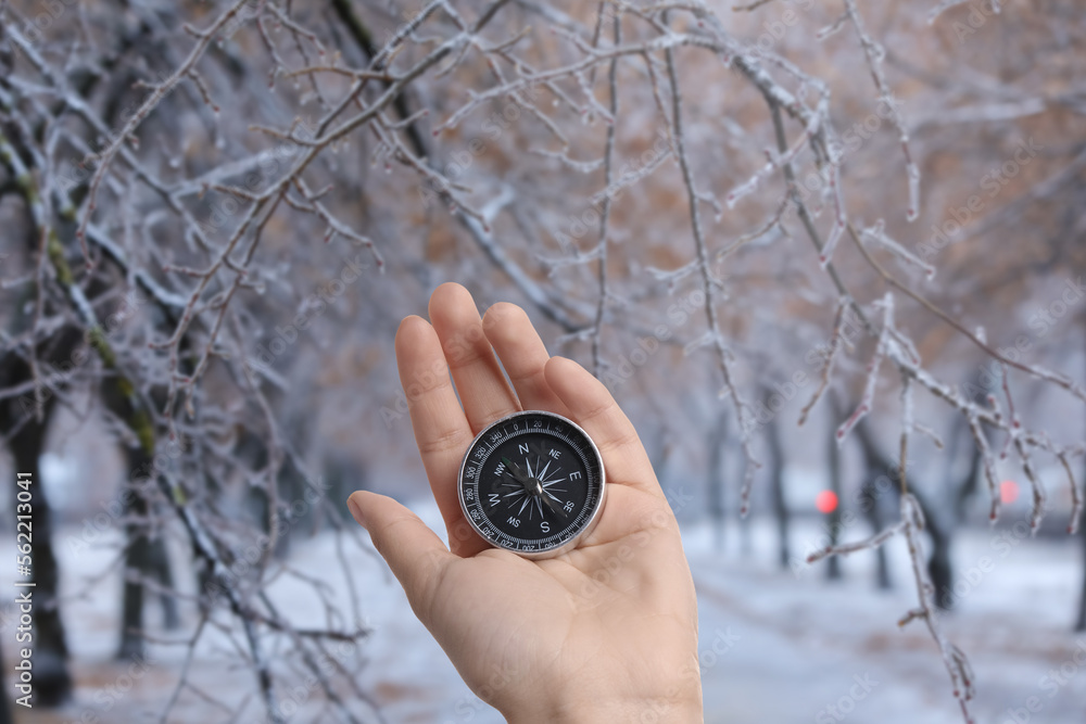 Human hand with compass in winter park