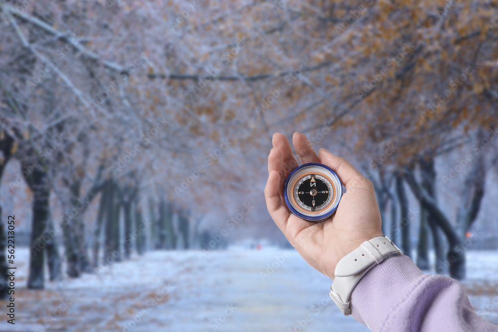 Human hand with compass in winter park