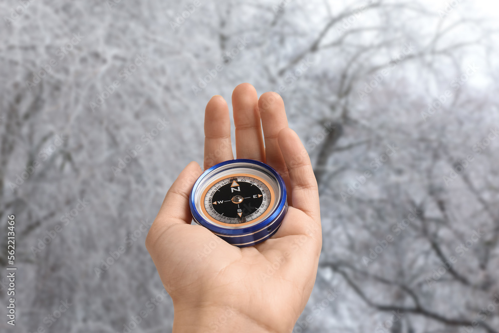 Human hand with compass on winter day