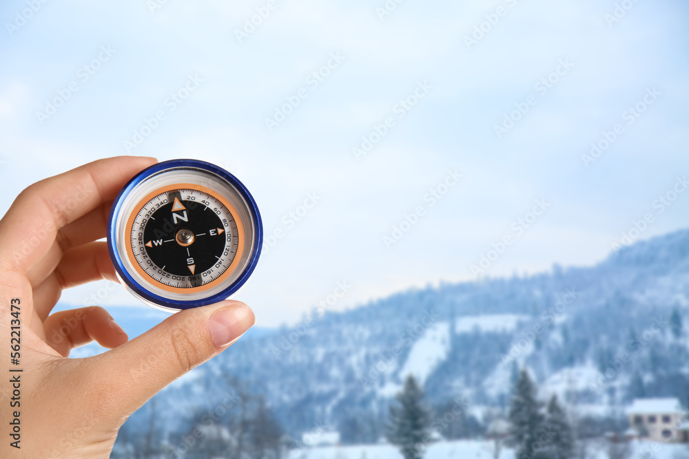 Human hand with compass at winter resort