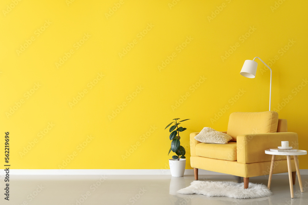 Interior of living room with yellow armchair, table and lamp