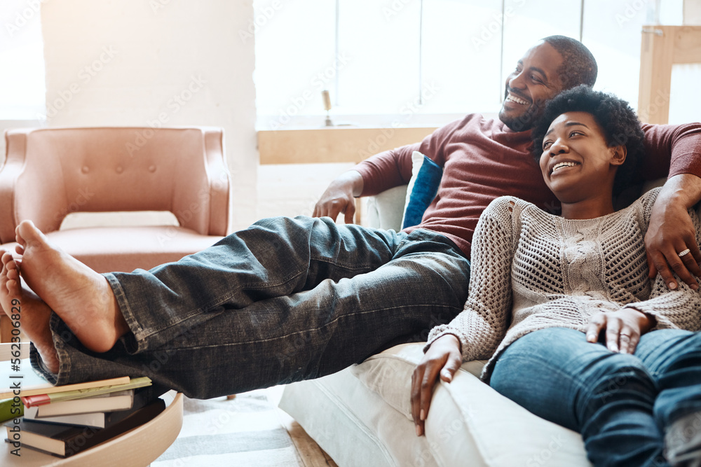 Couple, relax and watching tv on a sofa, happy and smile while bonding in their home together. Telev