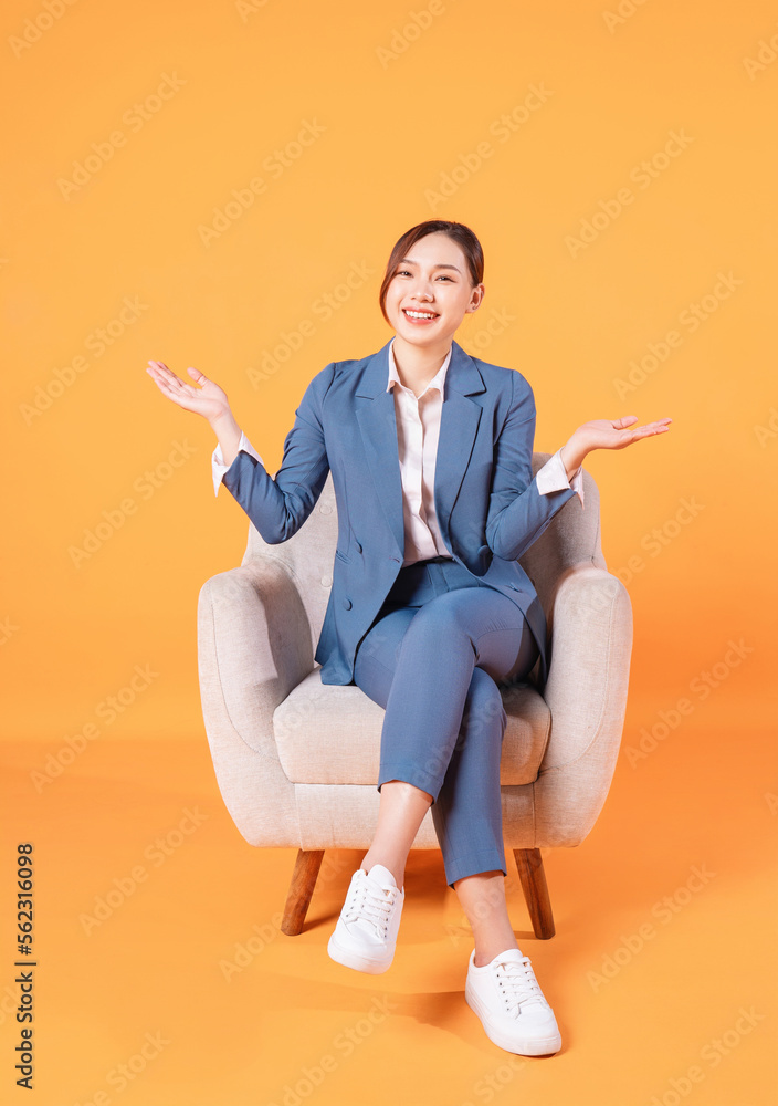 Photo of young Asian businesswoman sitting on armchair