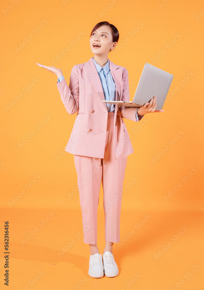 Young Asian businesswoman using laptop on background