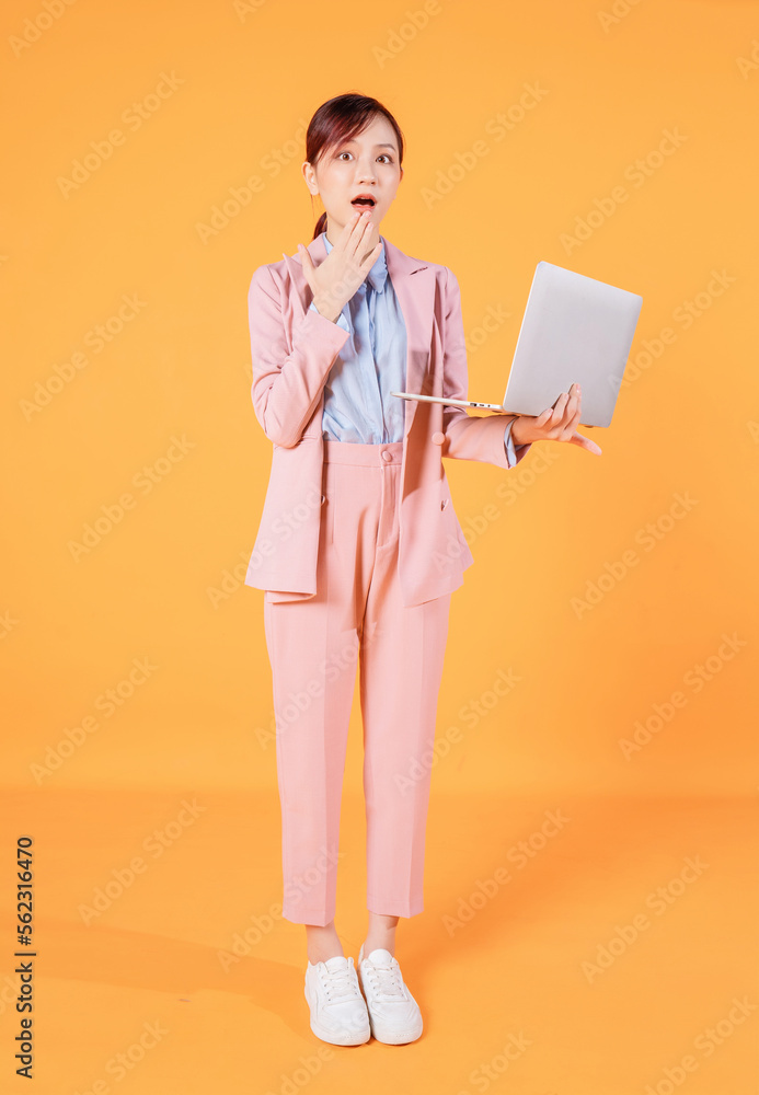 Young Asian businesswoman using laptop on background