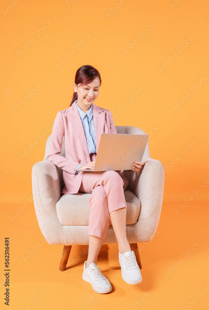 Young Asian businesswoman using laptop on background