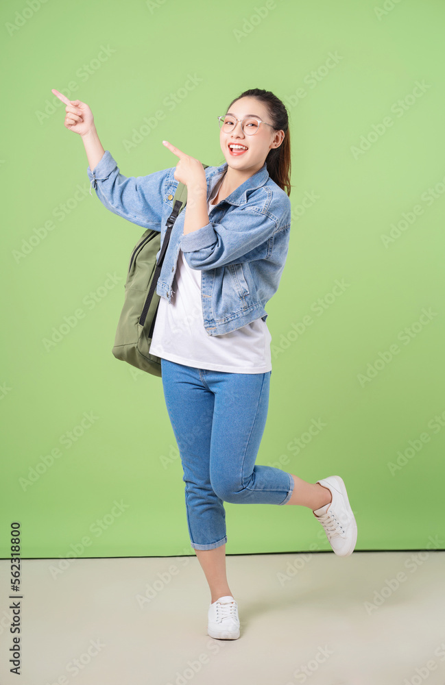 Photo of young Asian college girl on green background