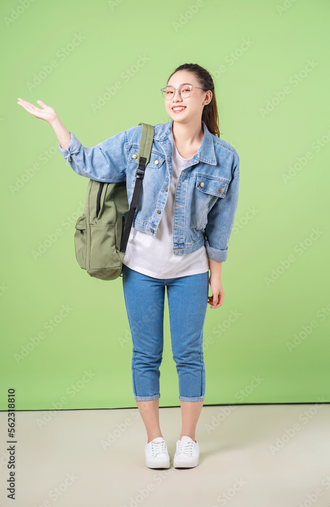 Photo of young Asian college girl on green background