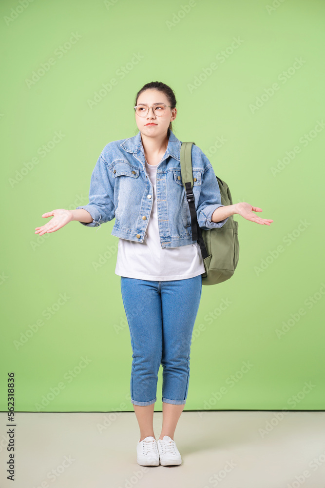 Photo of young Asian college girl on green background