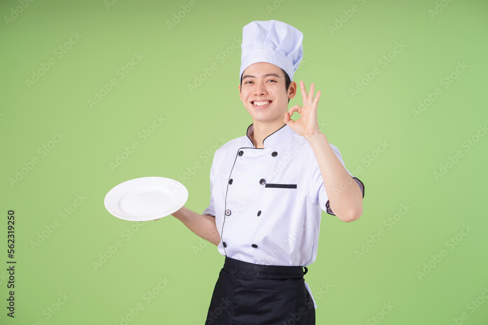 Photo of young Asian male chef on background