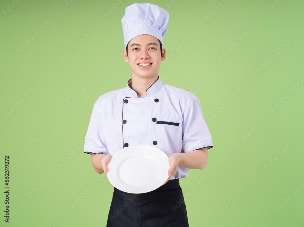 Photo of young Asian male chef on background