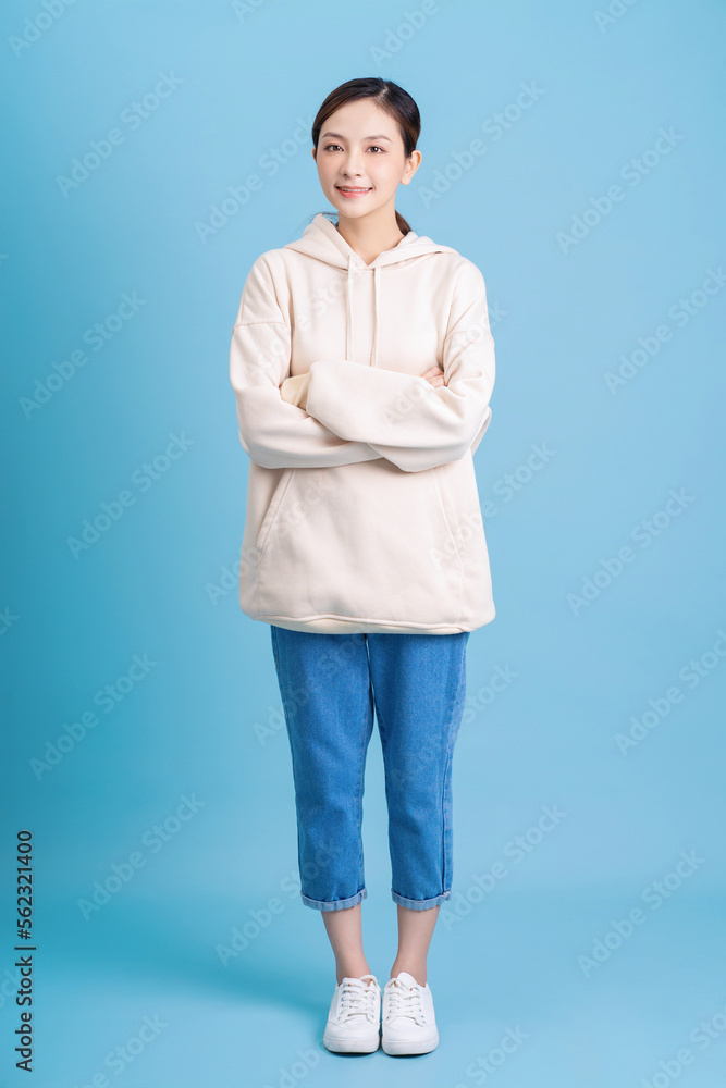 Photo of young Asian girl posing on blue background