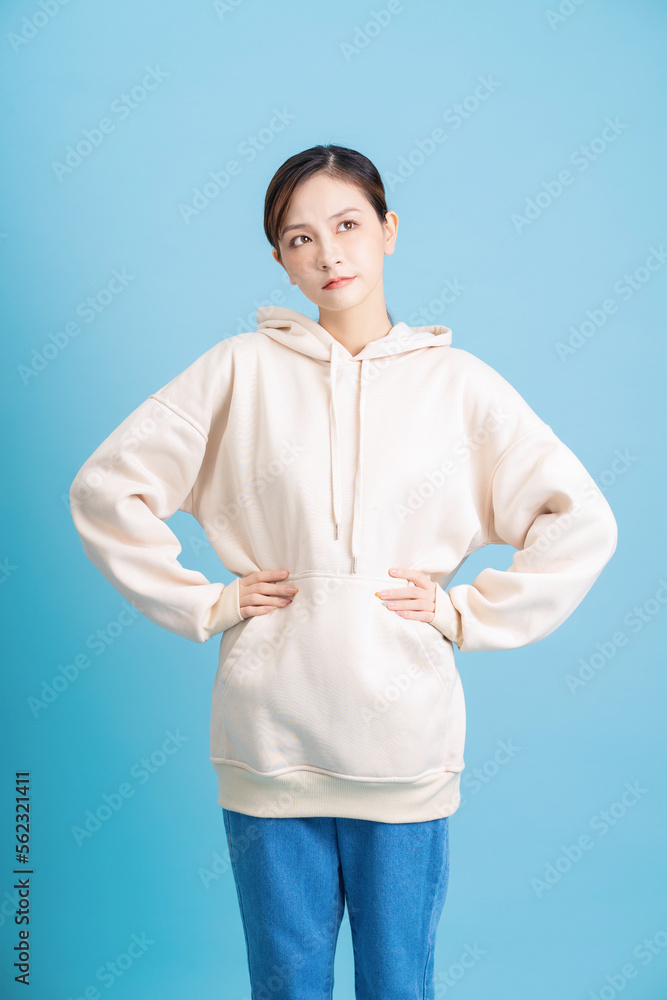 Photo of young Asian girl posing on blue background