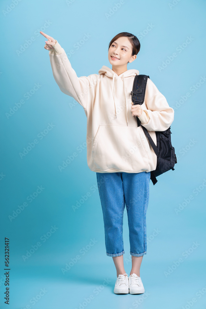 Full length photo of young Asian student girl on background