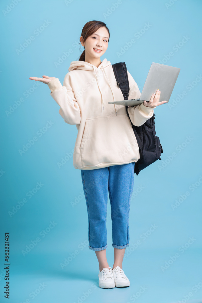 Full length photo of young Asian student girl on background