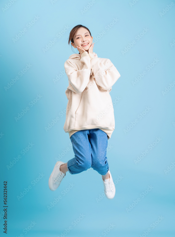 Photo of young Asian girl posing on blue background