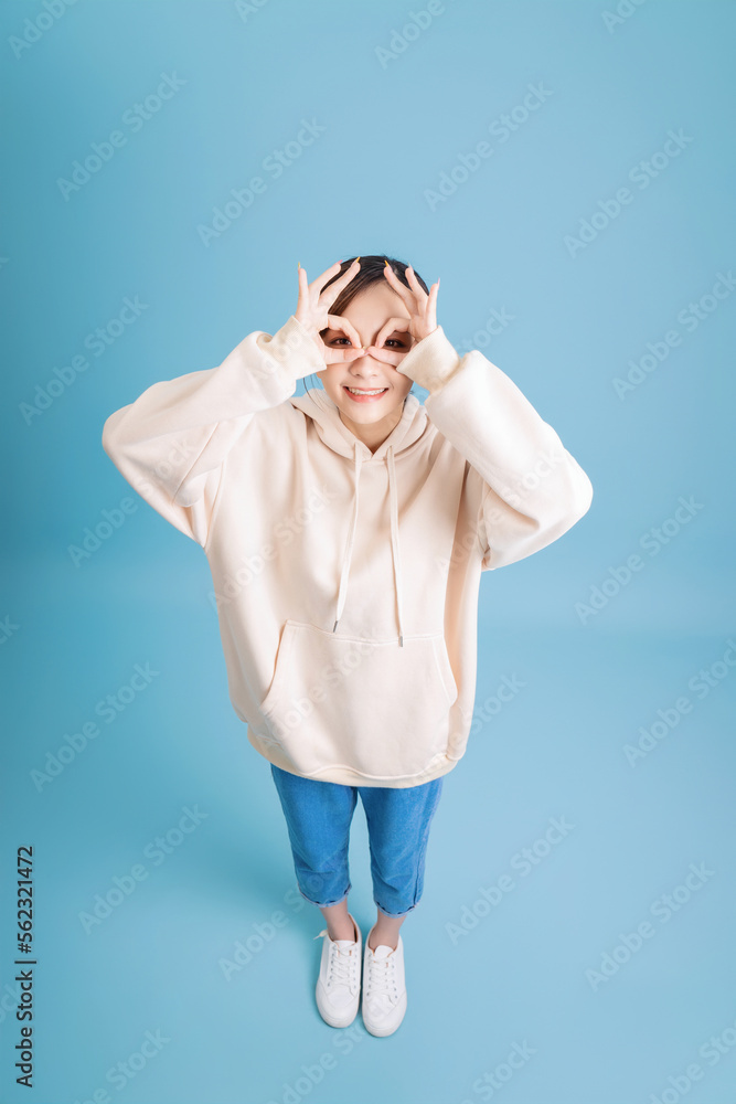 Photo of young Asian girl posing on blue background