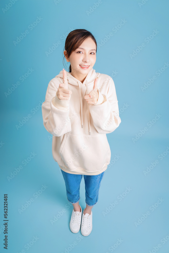 Photo of young Asian girl posing on blue background