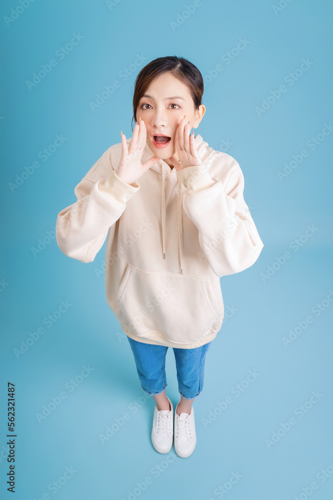 Photo of young Asian girl posing on blue background