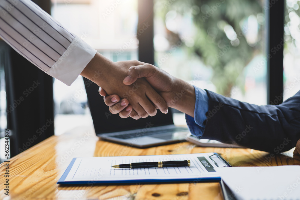 Businessmen shaking hands after reaching legal contract agreement.