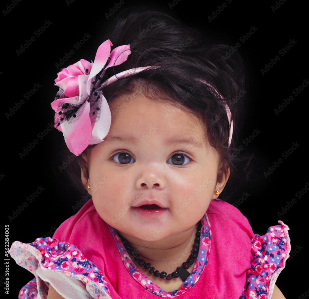 Portrait, baby or girl with an innocent infant in studio on a black background in floral clothes. Ki