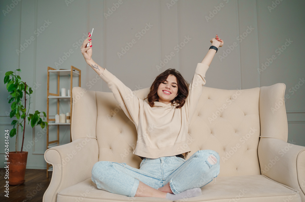 Happy young woman taking self photo on camera, weekend at home, sitting in living room.