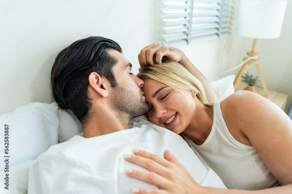 Caucasian new marriage couple lying on bed and looking at each other. 