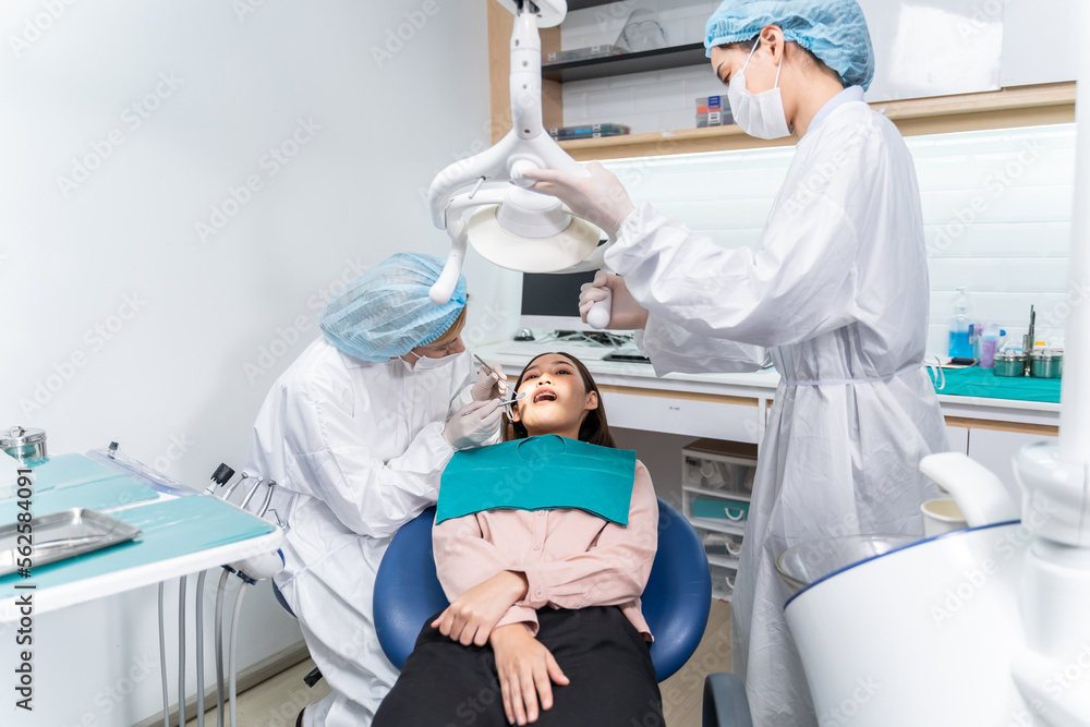 Caucasian dentist examine tooth for young girl at dental health clinic. 