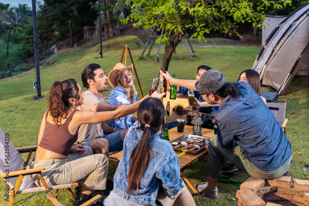 Group of diverse friend having outdoors camping party together in tent. 